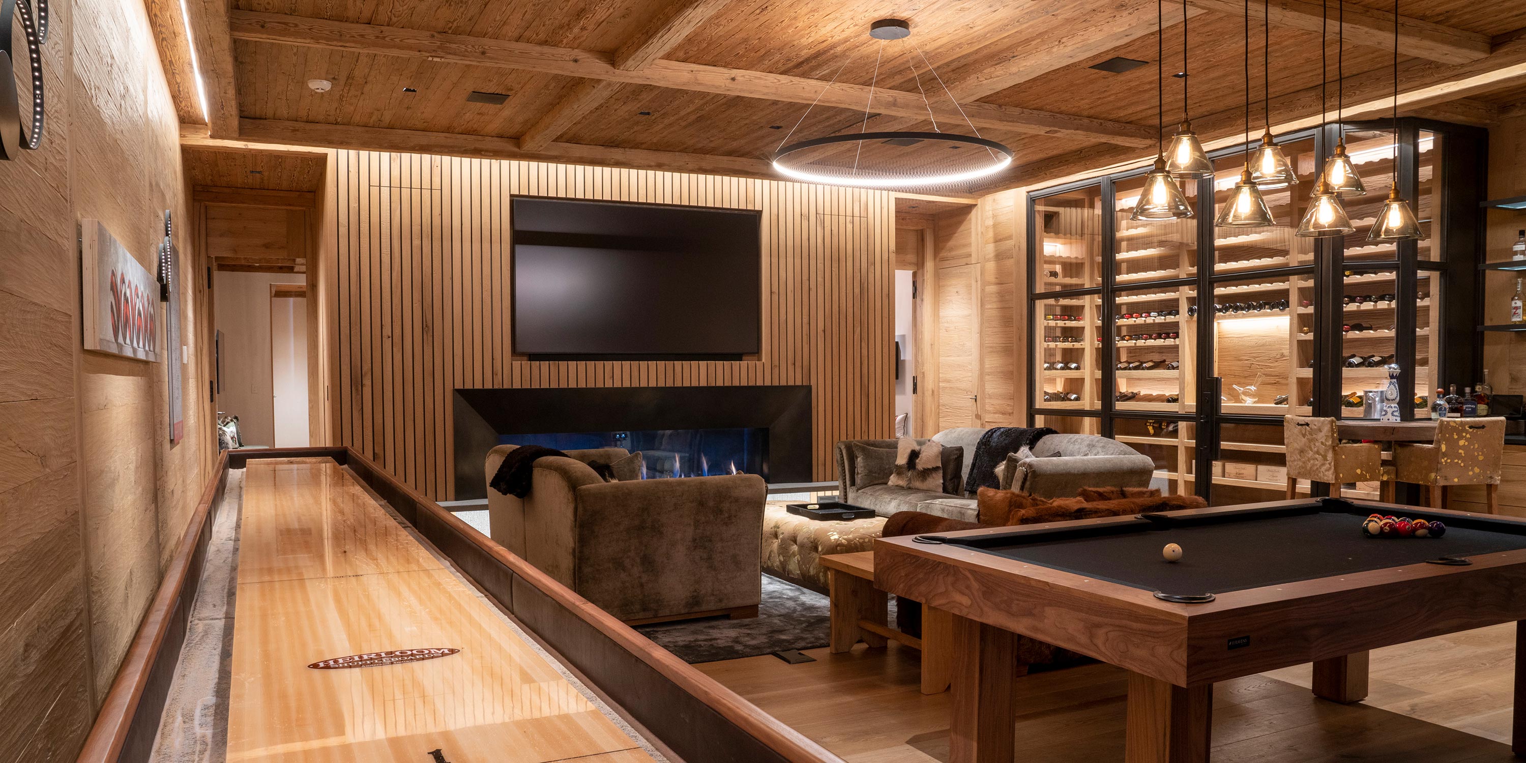 Cozy game room with shuffleboard, pool table, fireplace, and wine display