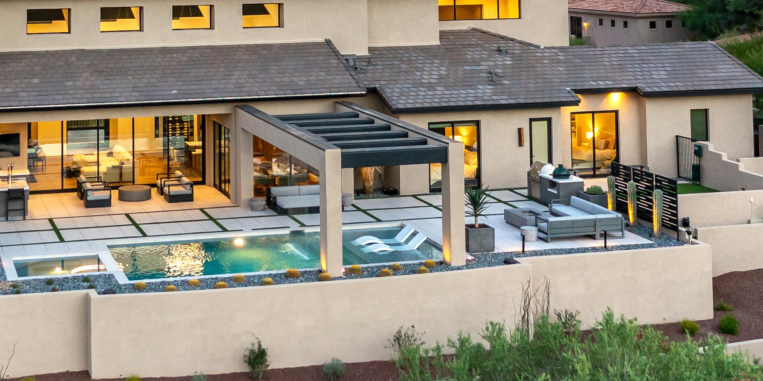 Elegant patio with pool, outdoor kitchen, and modern lounge seating