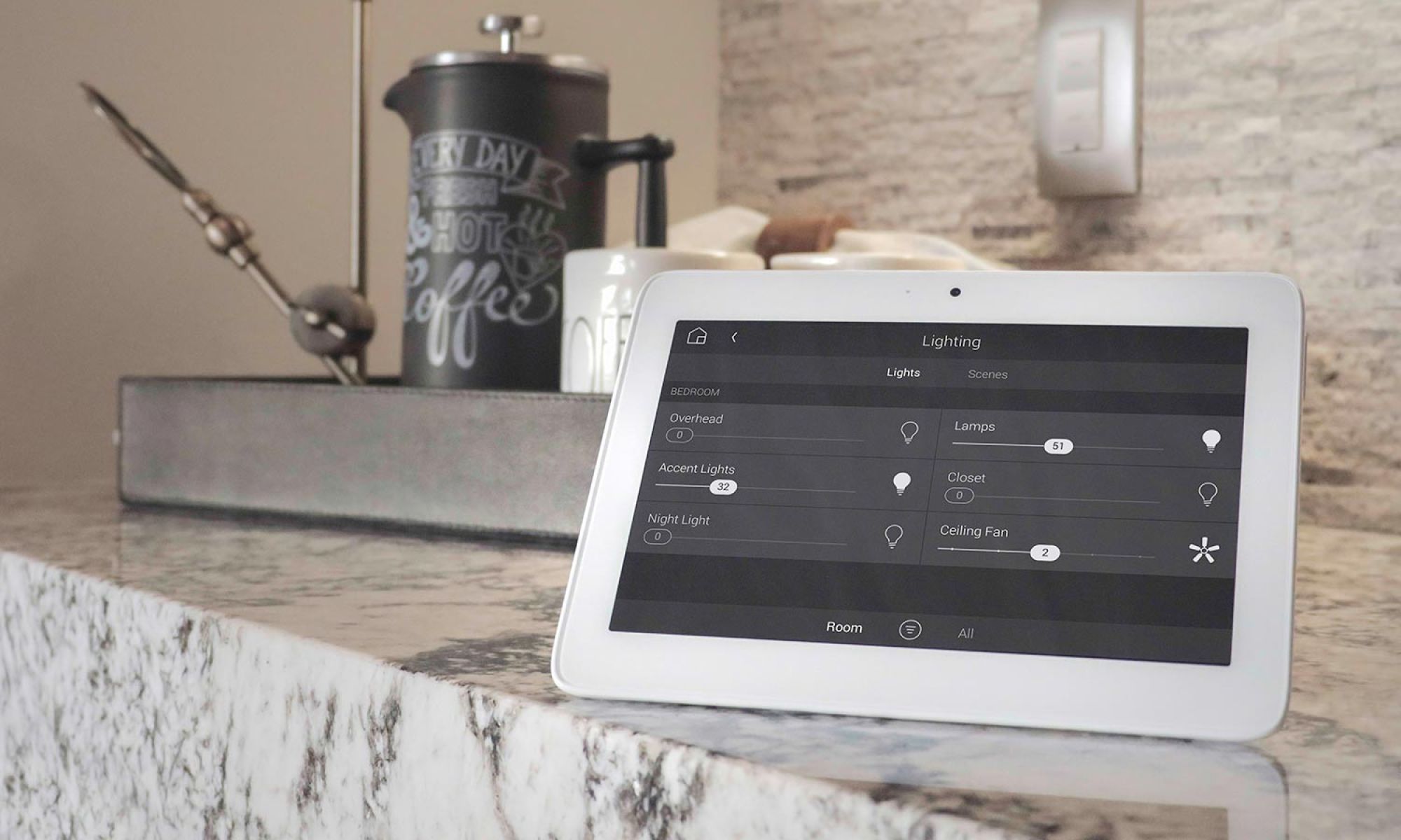 Tablet displaying smart lighting controls on a kitchen counter next to a coffee maker