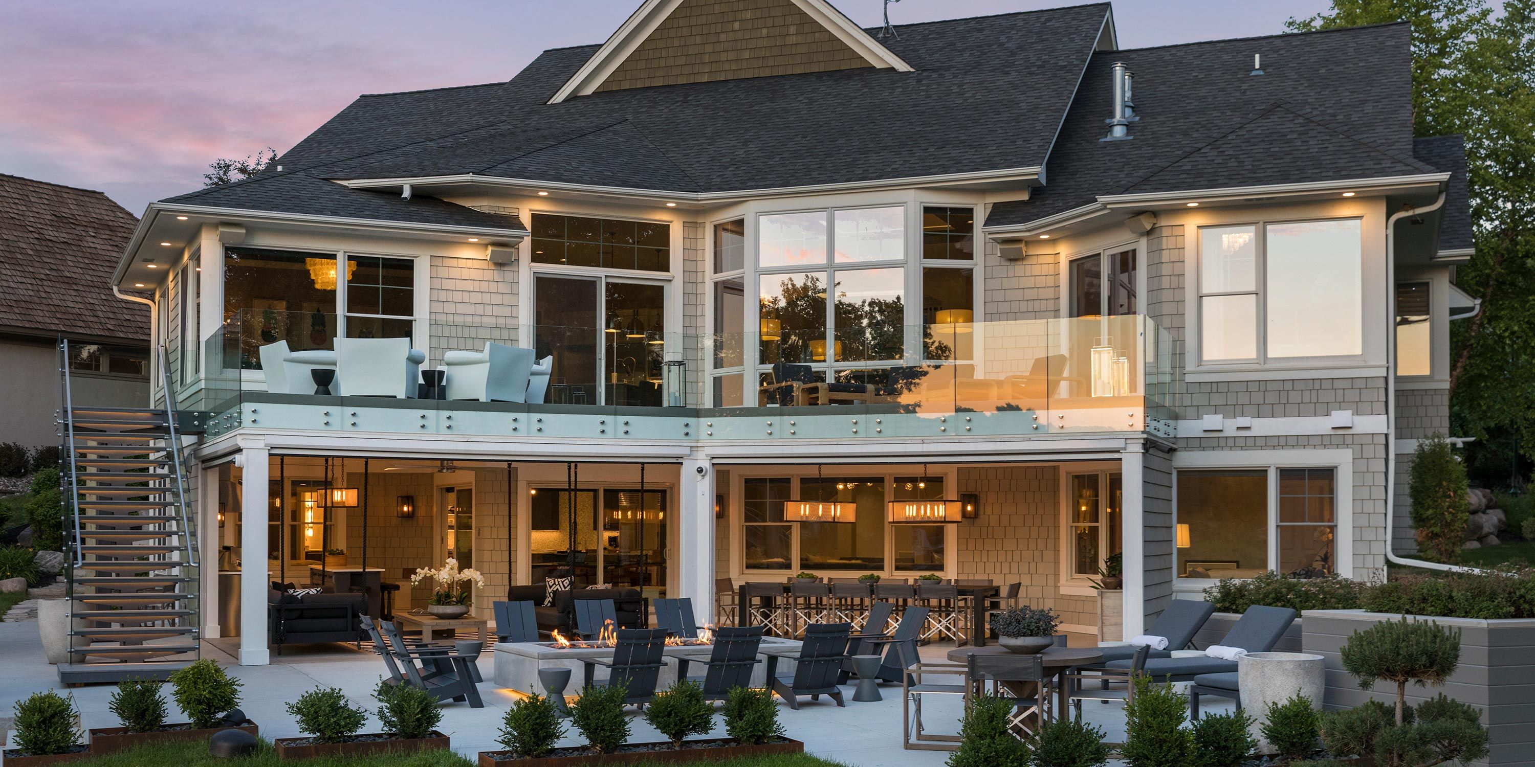 Modern multi-story home with extensive outdoor lighting and glass railings