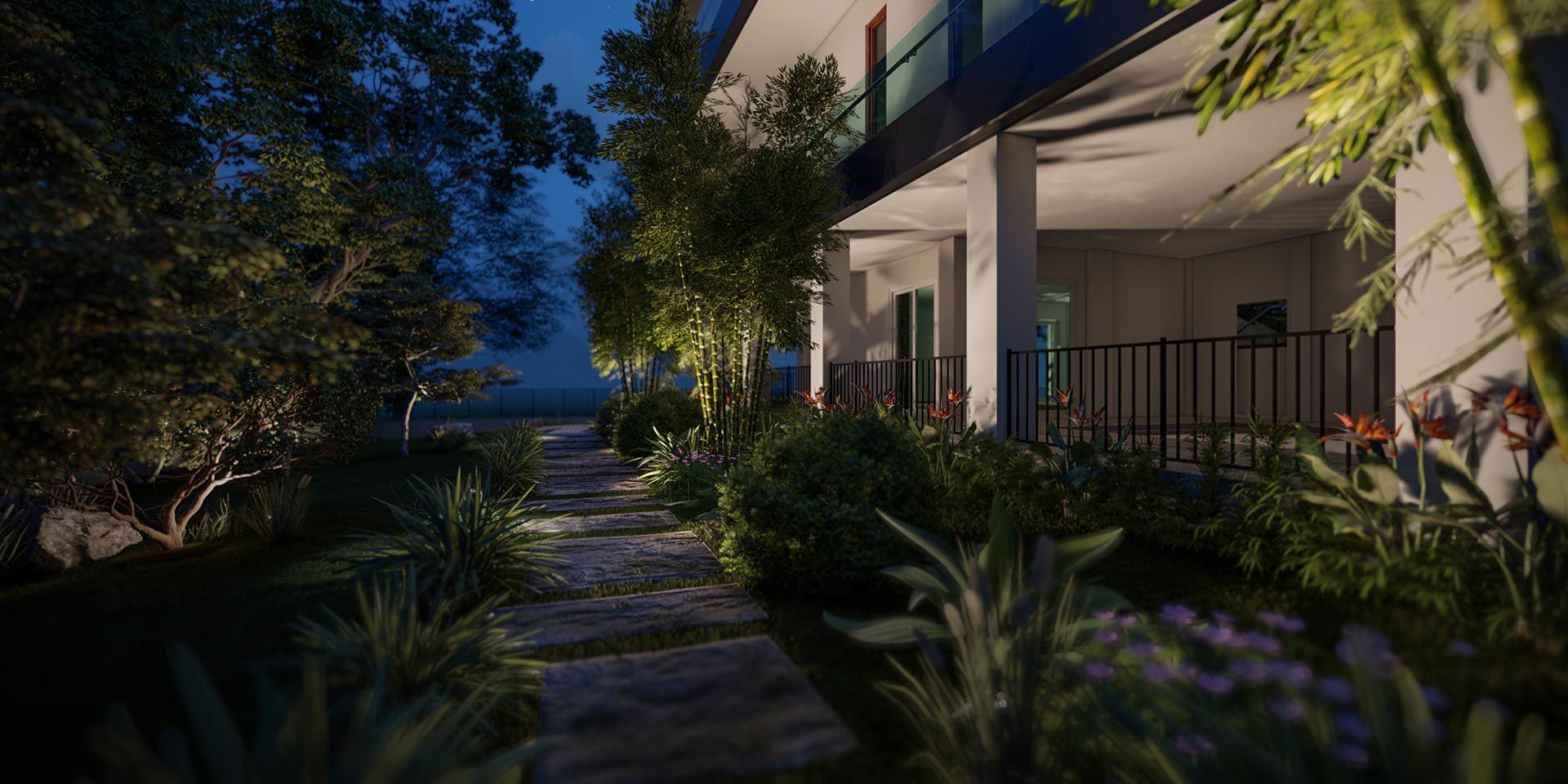 Stone path through landscaped garden with dramatic nighttime lighting
